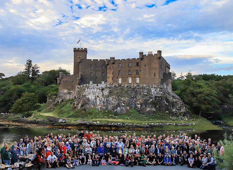 Large group posing by waterfront castle