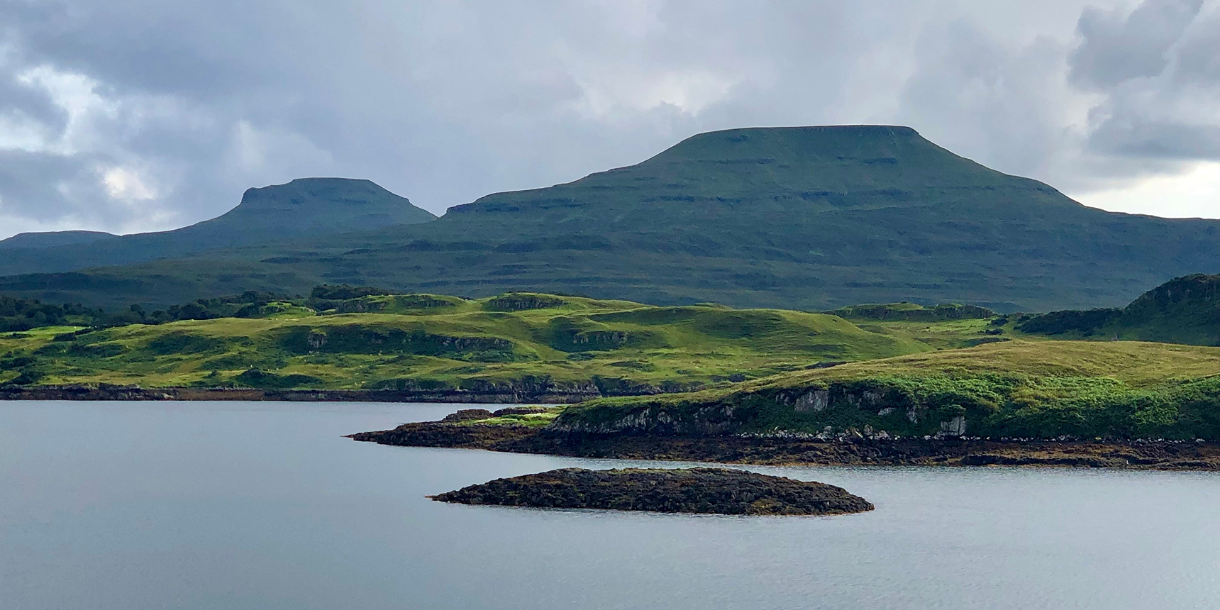 Coastal bay with green hills and mountains