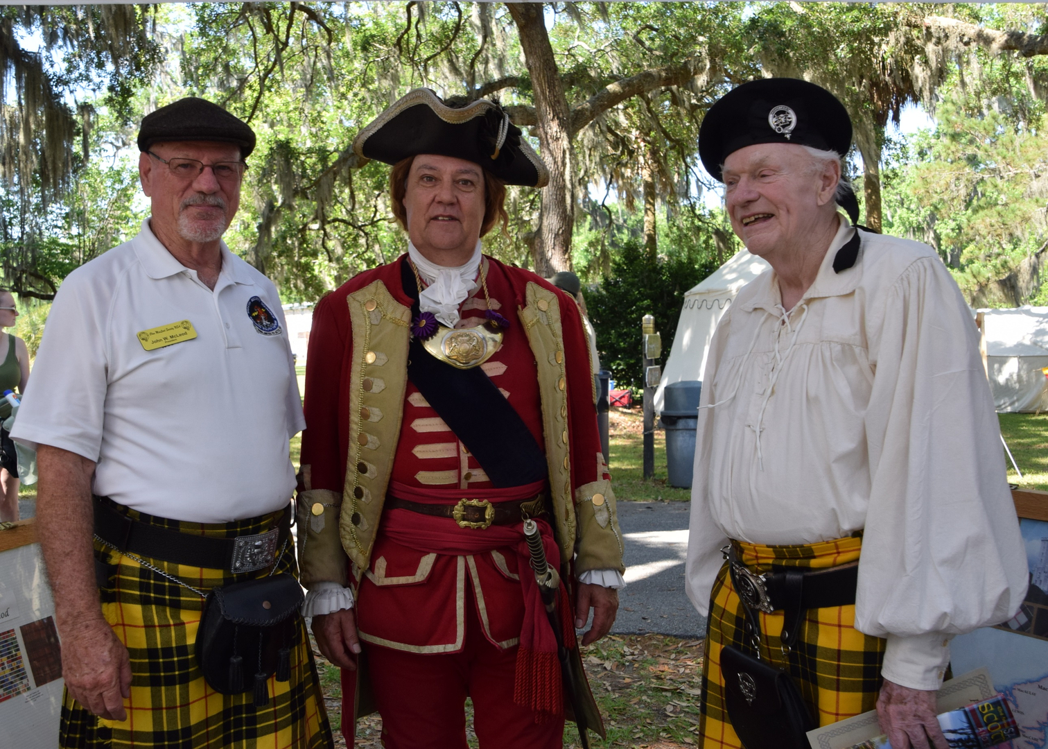 Three men in historical and Scottish attire.