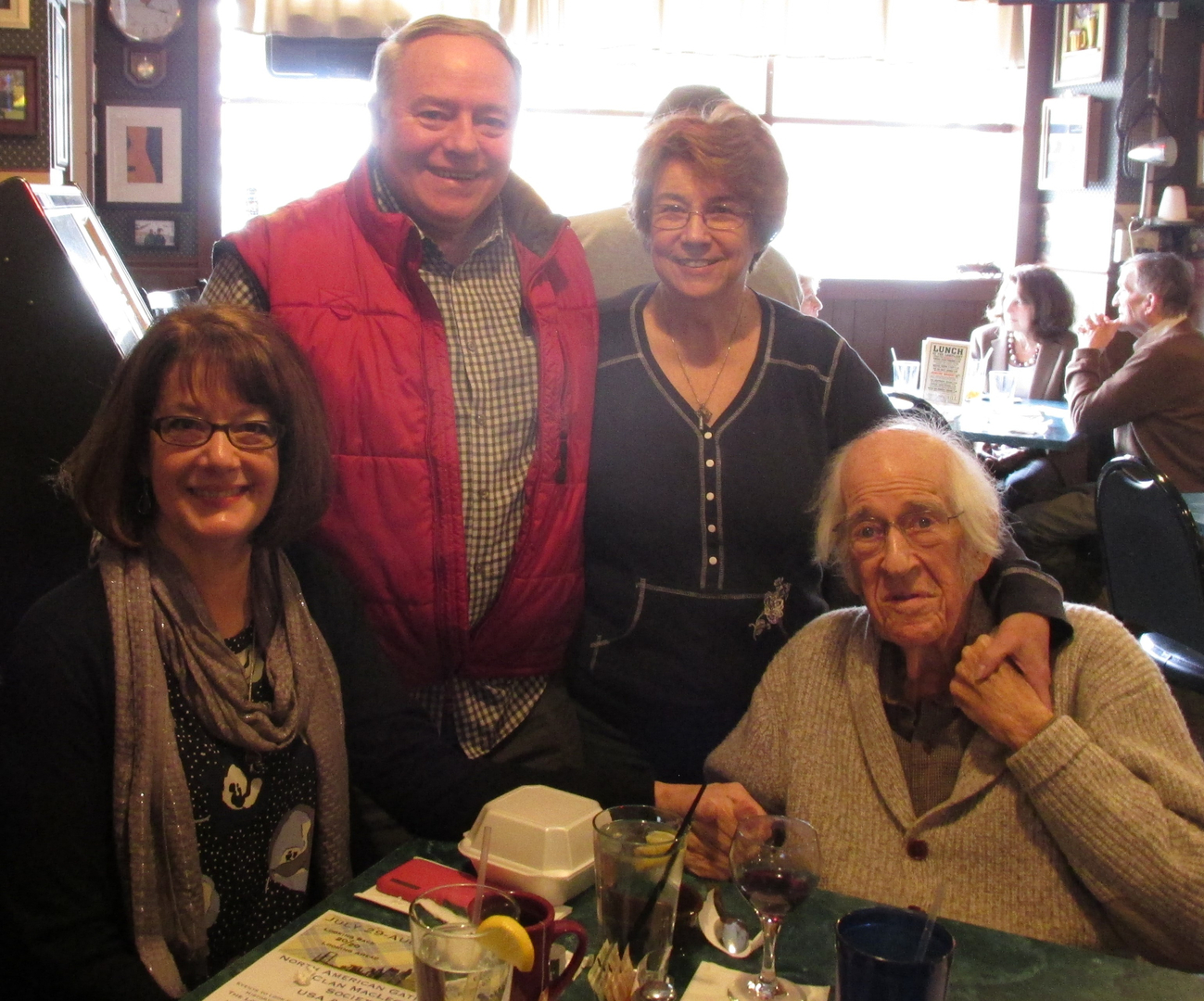 Four people smiling at a restaurant table.