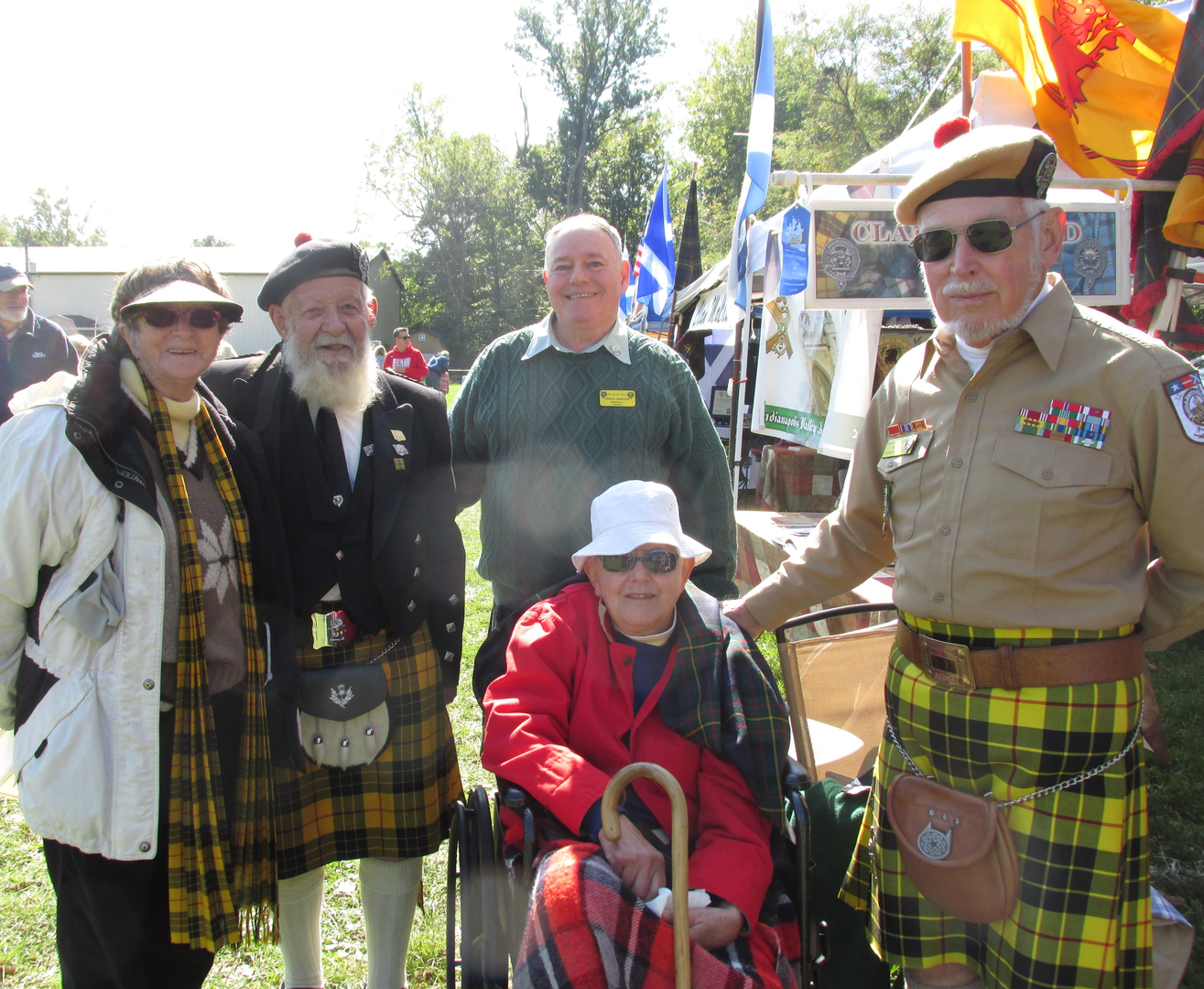 Group in traditional Scottish attire outdoors.