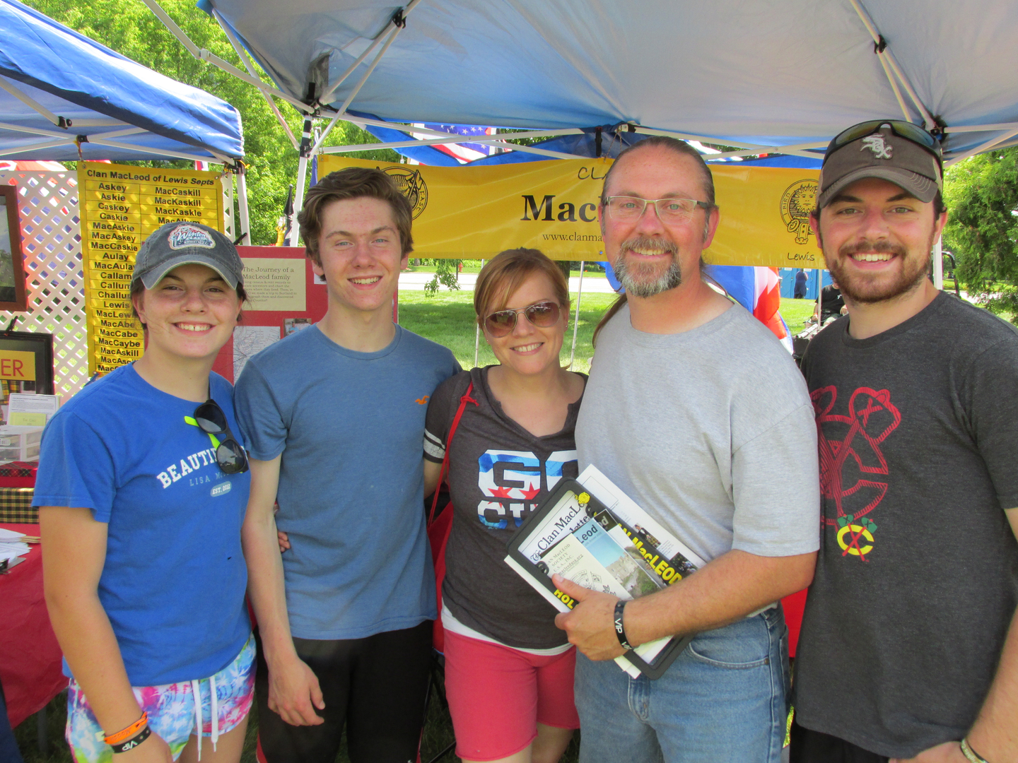 Group smiling under a festival tent.