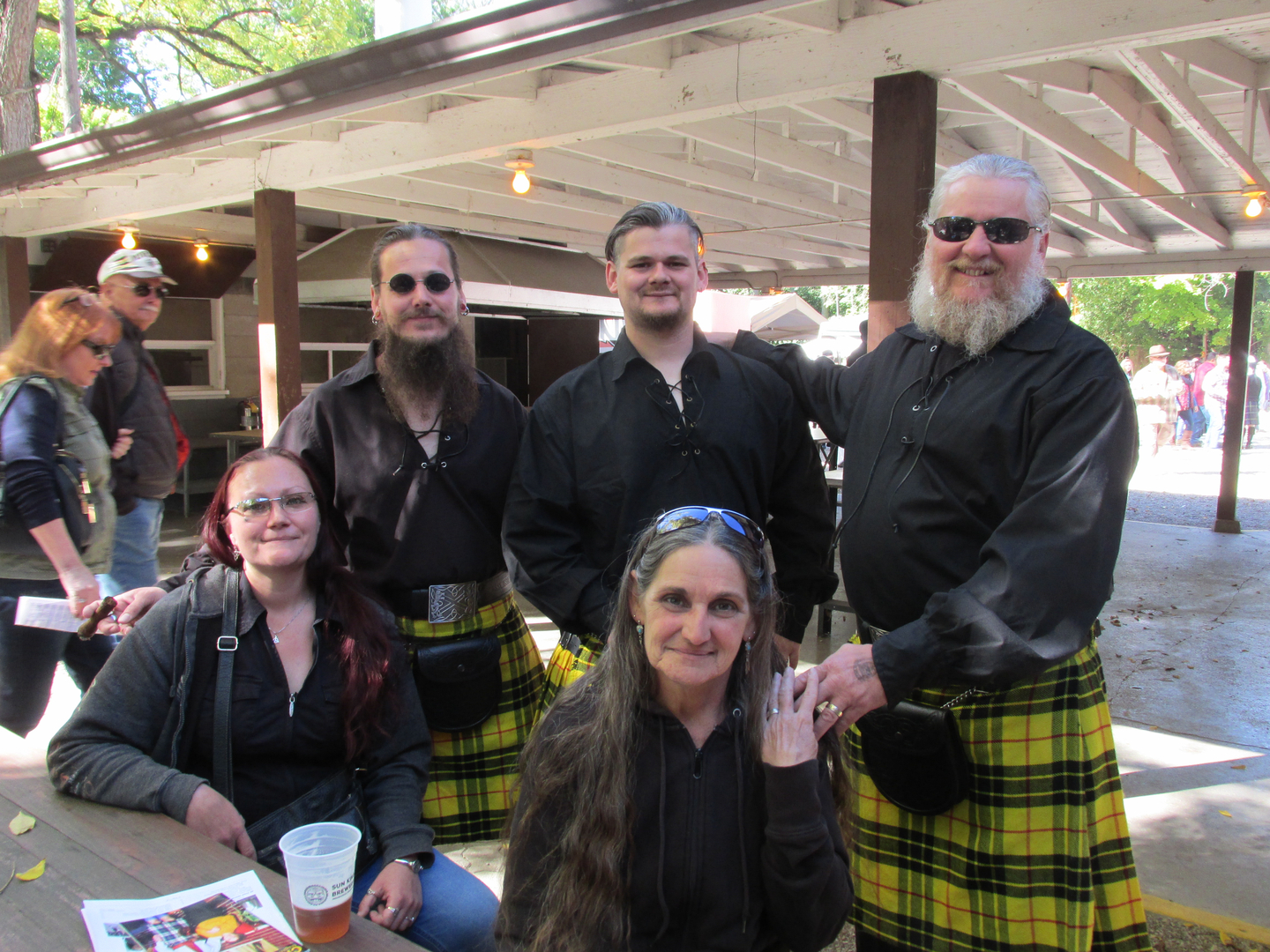 Group in black shirts with yellow kilts.
