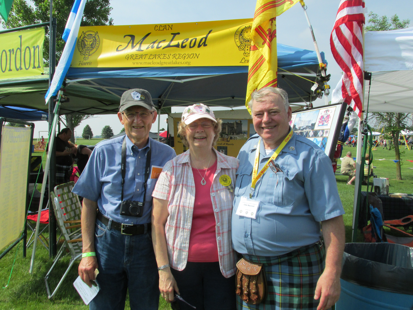Three people smiling at outdoor event.
