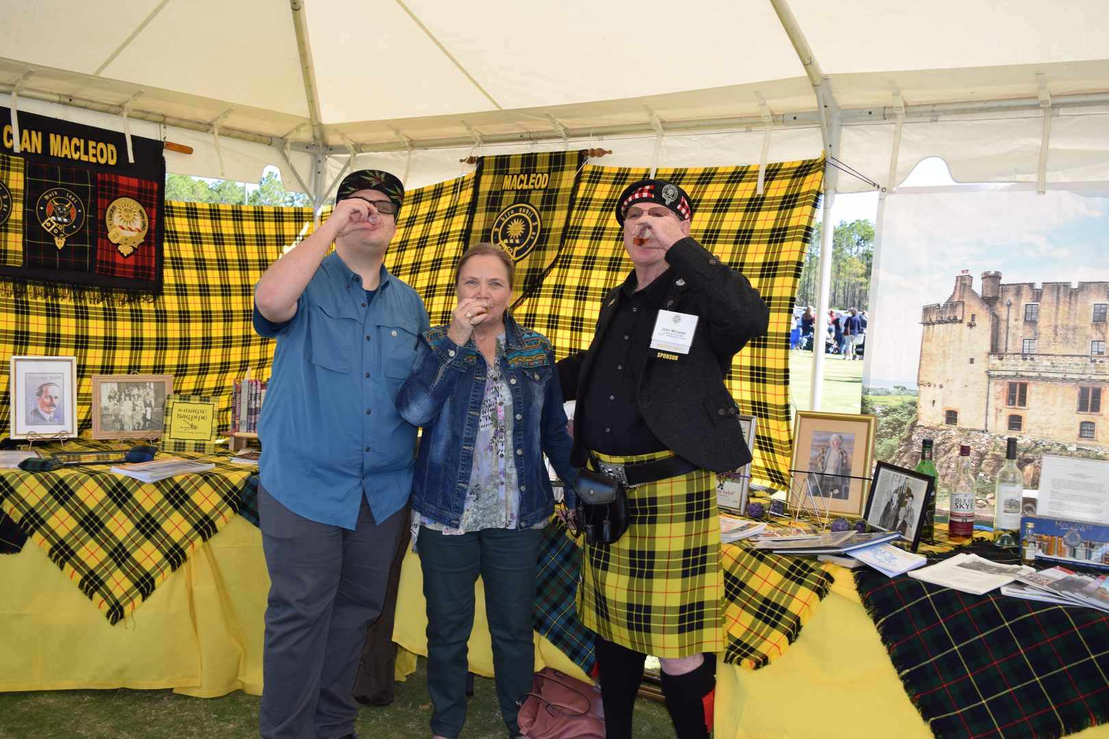 Three people posing at Scottish festival.