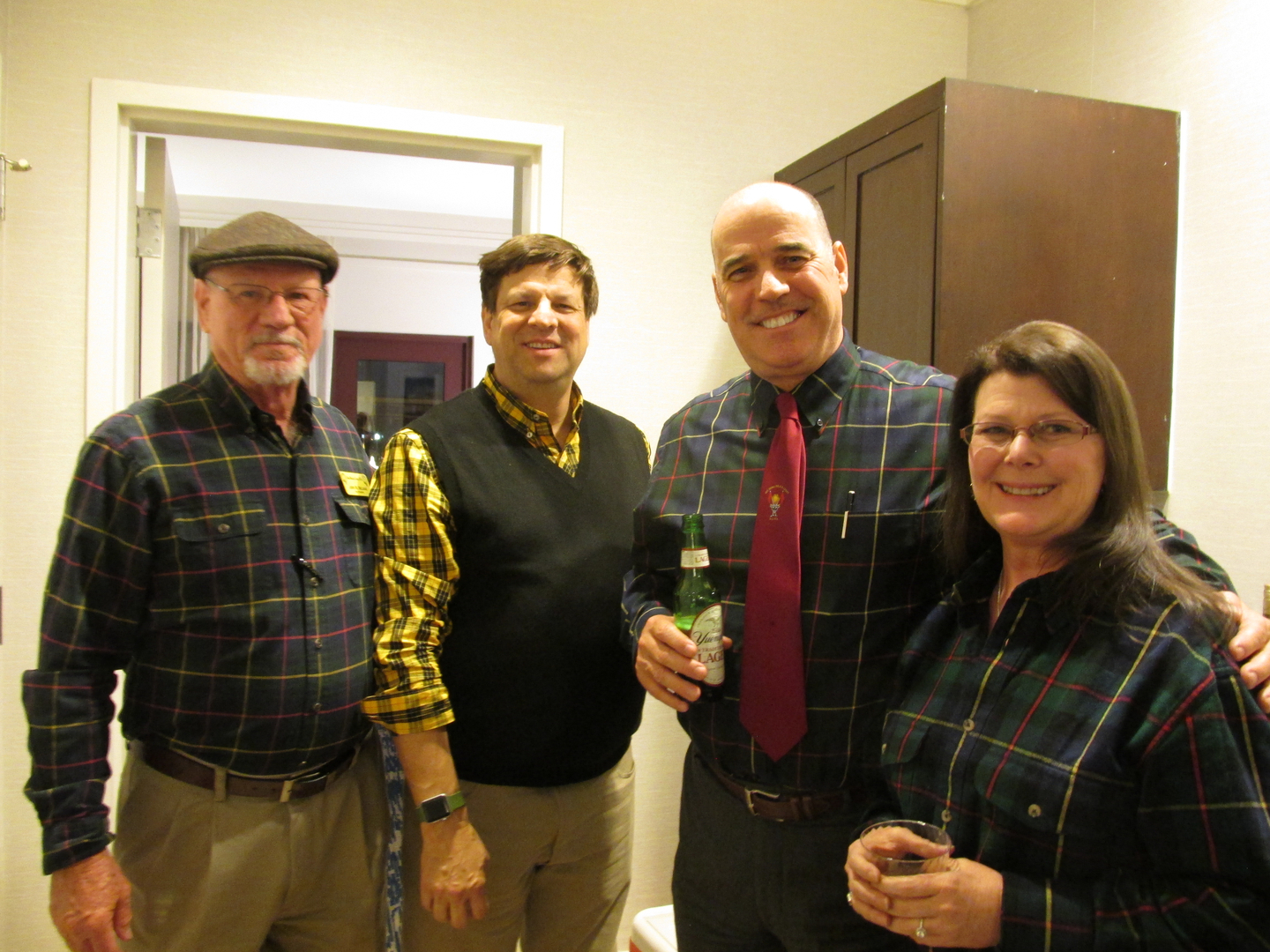 Four people smiling at a casual gathering.