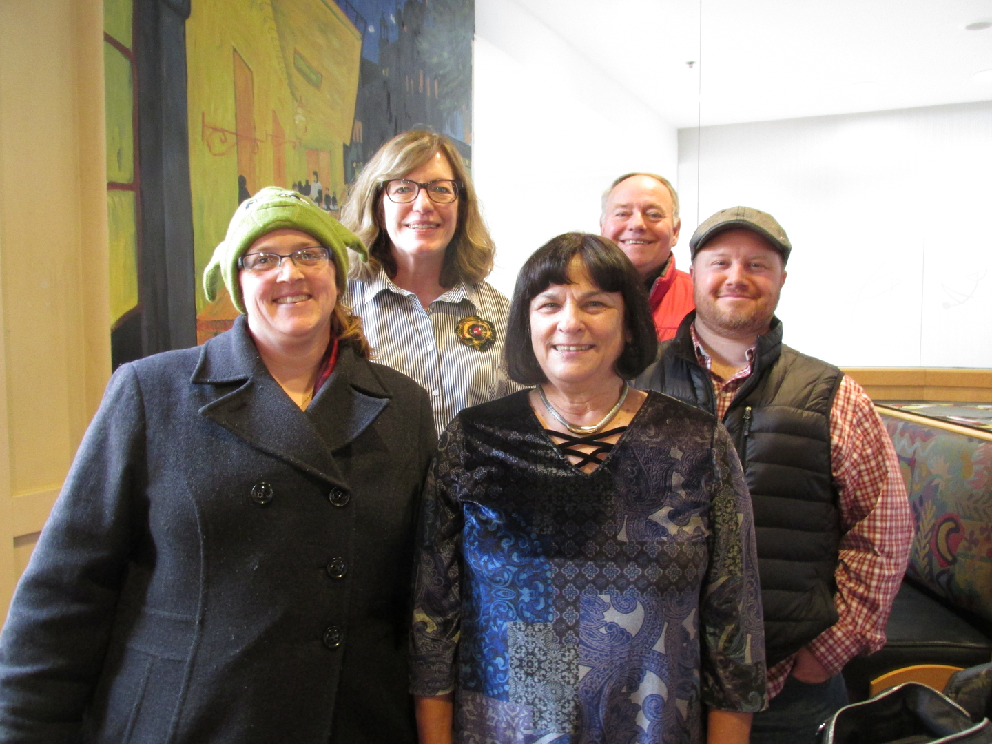 Group of five people smiling indoors.