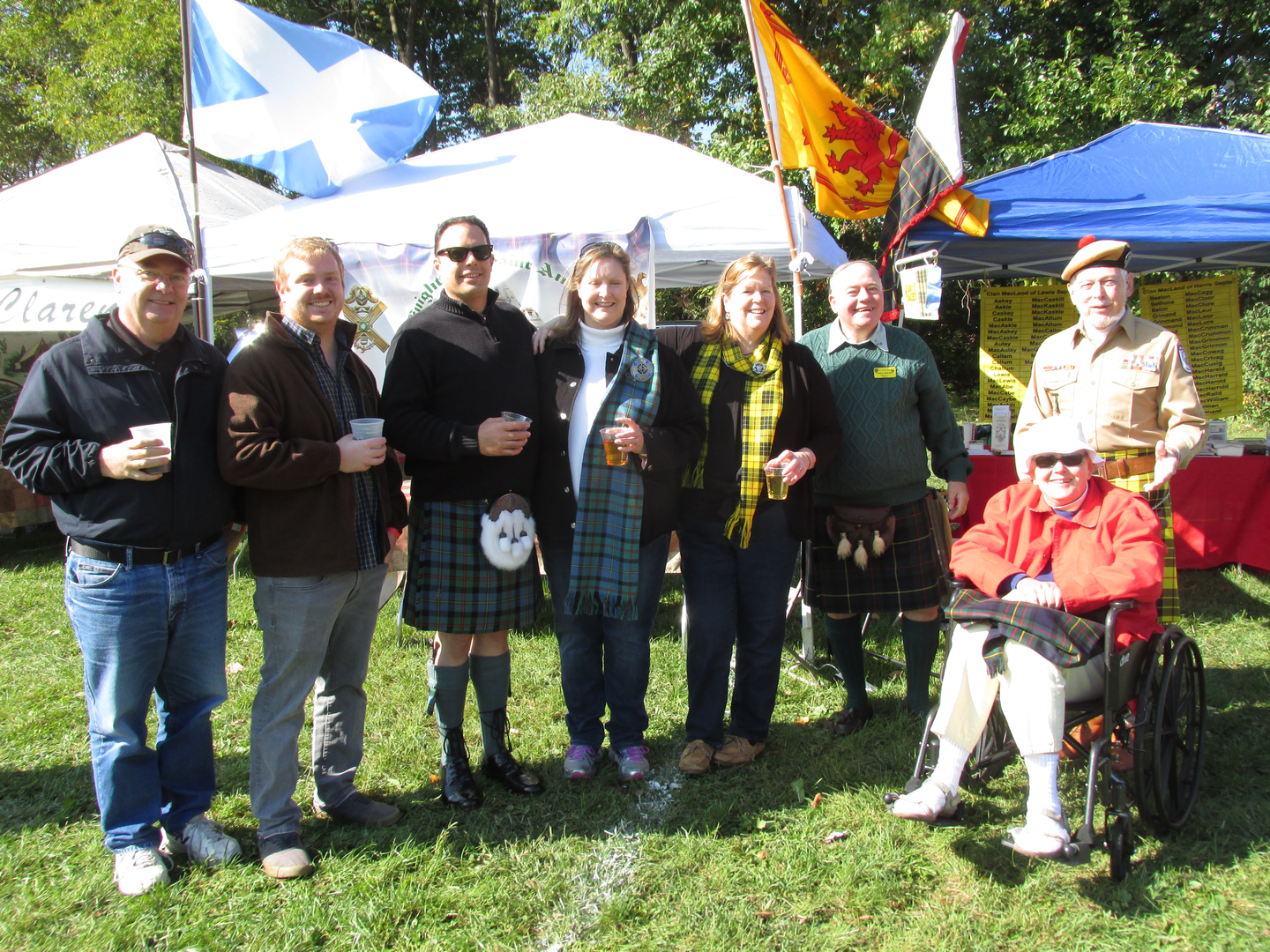 Group celebrating at outdoor festival with flags.