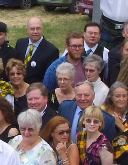 Group of people smiling at outdoor event.