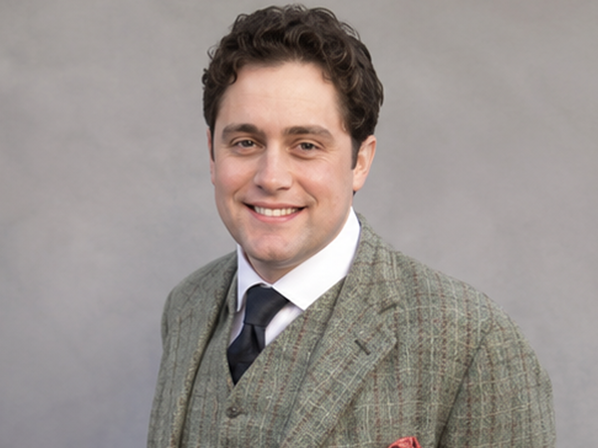 Smiling man in a suit and tie.