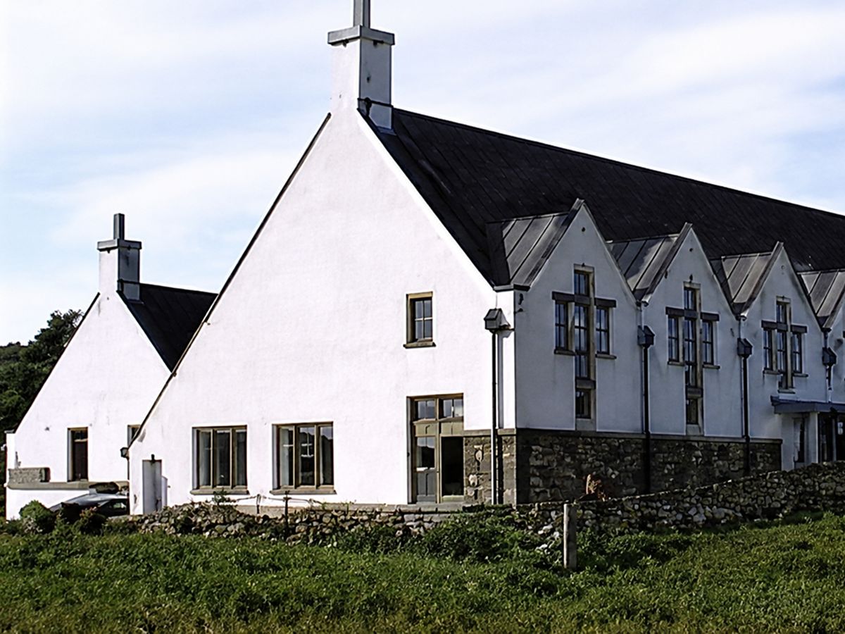 White church with slate roof and crosses.