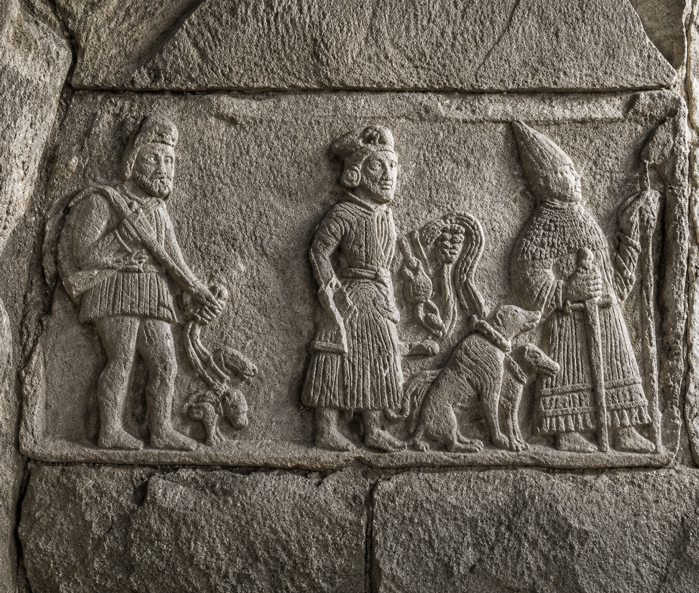 Ancient stone carving with three figures.
