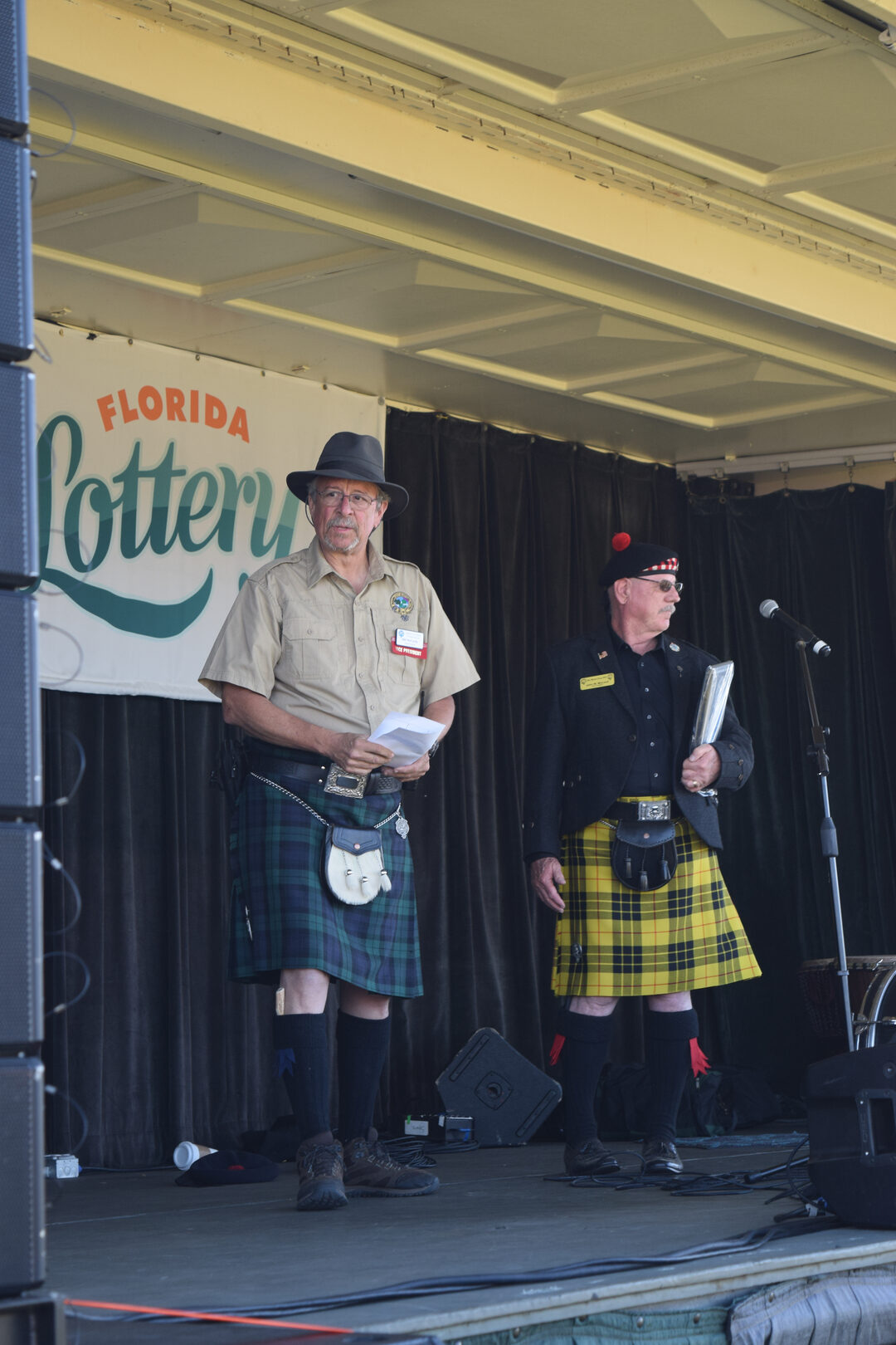 Men in kilts on outdoor stage.