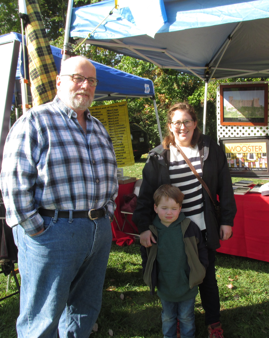 Family under tent at outdoor market.