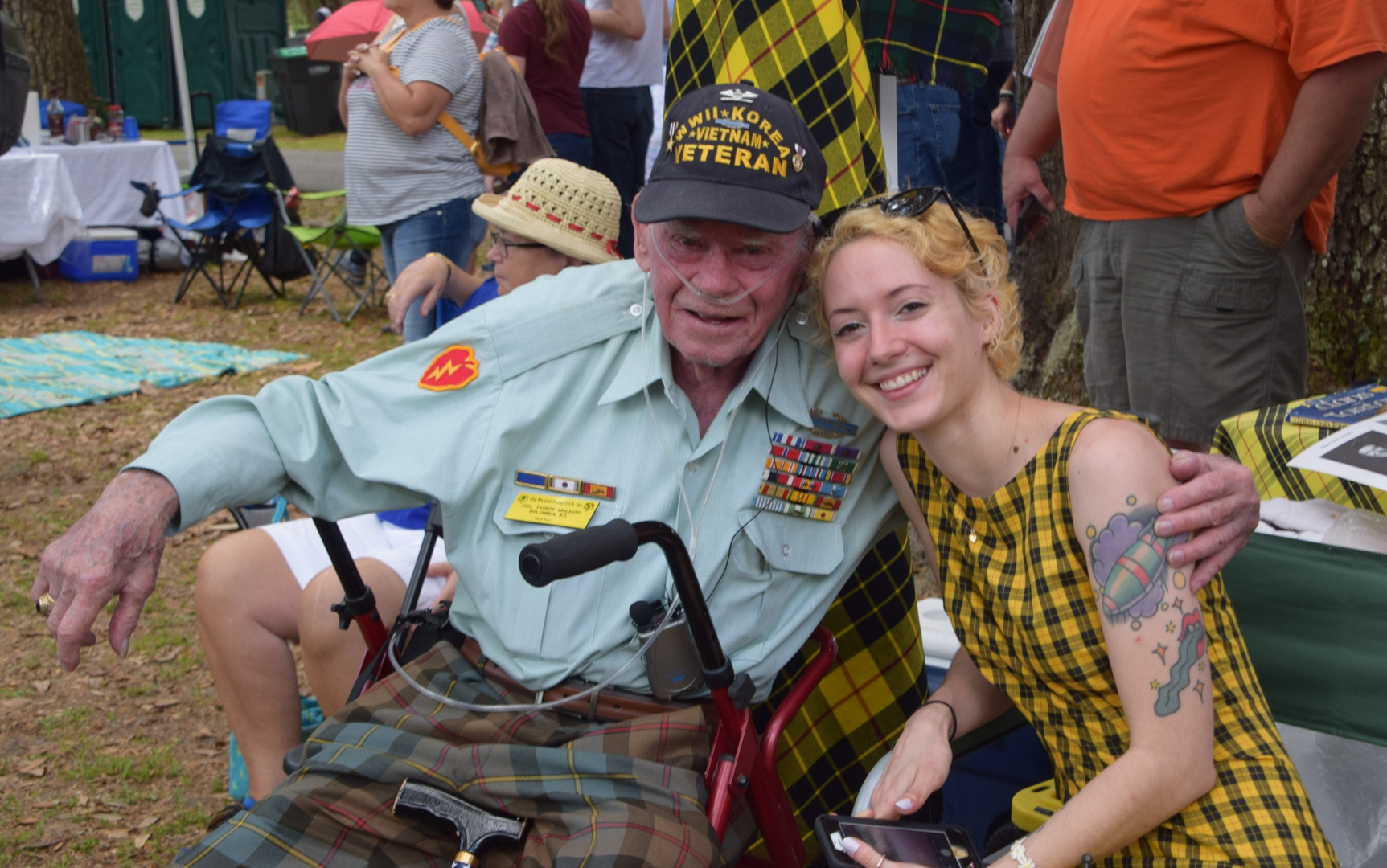 Veteran and young woman smiling outdoors.